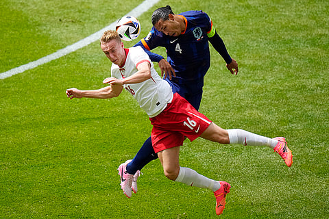 Adam Buksa and Virgil van Dijk challenge for the ball